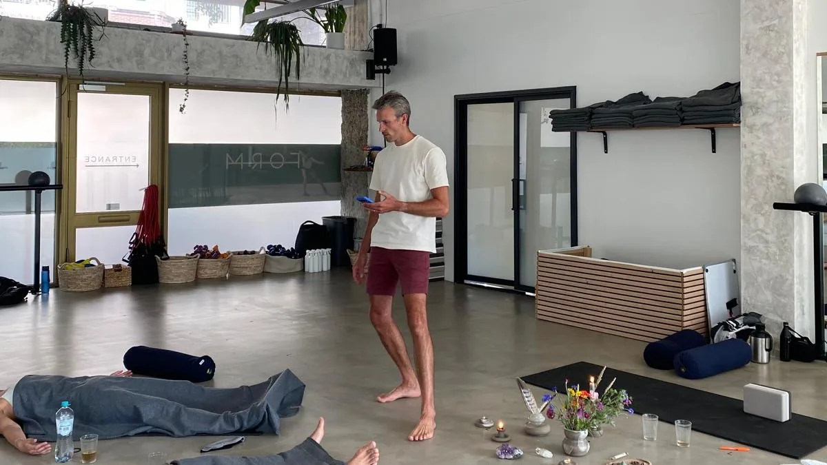 Ademsessie in een kring, deelnemers liggend op matjes